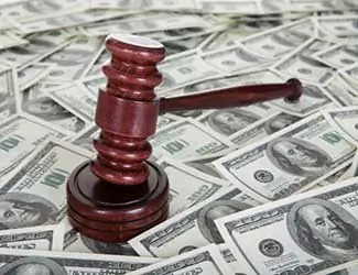 Mazo de juez de madera descansando sobre billetes de dólar estadounidenses dispersos